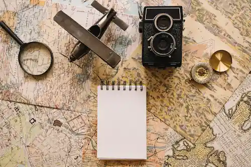Illustration of a map with a small airplane, compass, camera, and a loop, representing travel and exploration.